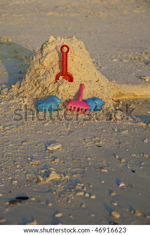 Children\'s toys for the game in the sand. Sunset light.