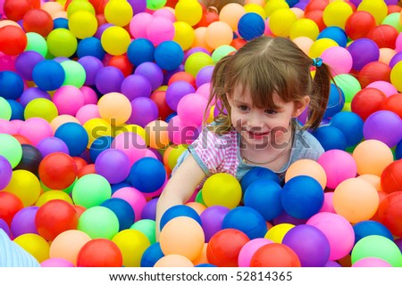 Happy kid playing in the colorful balls