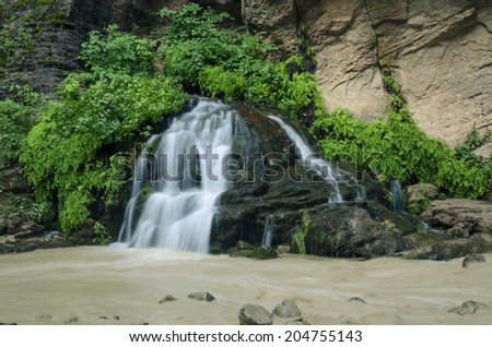 waterfall in canyon in muddy water