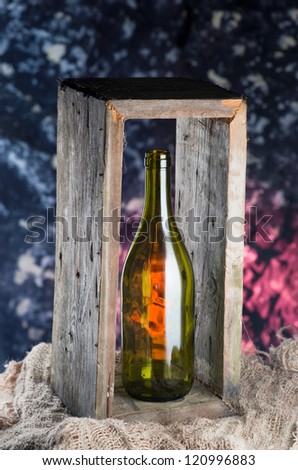 Empty bottle of wine in box on sackcloth