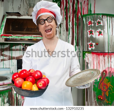 Cheerful cook with apples in the painted kitchen