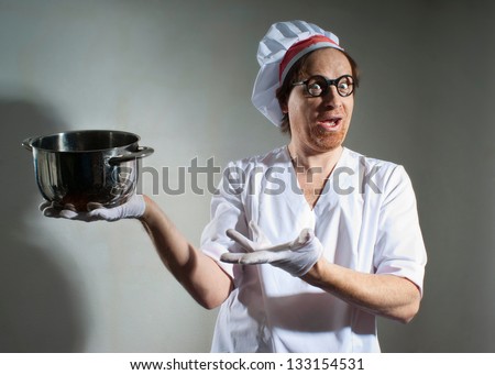Funny chef with pan on gray background
