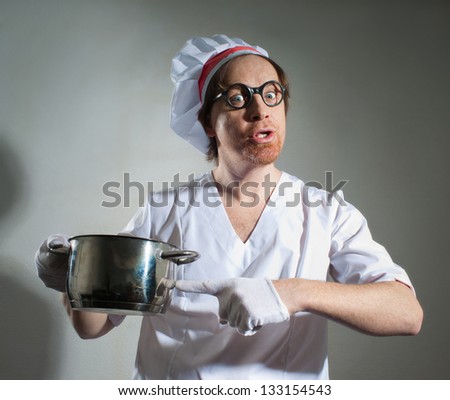 Funny chef with pan on gray background