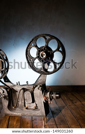 Movie projector with the film on the wooden floor