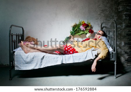 Tired man with bouquet lying on the bed