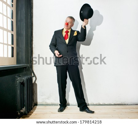 Actor in a black suit takes off his hat
