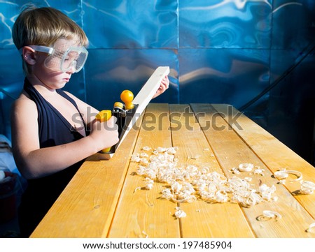 Small carpenter with the shaving plane at the table