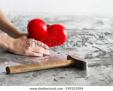 Shaken heart with hands and hammer