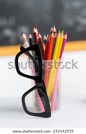 Glasses and set of pencils on the table in the classroom