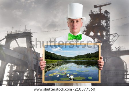 Man with landscape in hands on background of the factory