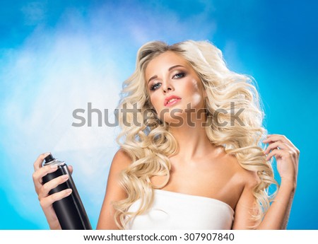 Beautiful blonde woman with a hair spray