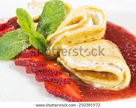 A set of pancakes with strawberries and sauce on white plate on white background isolated