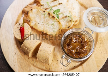 Chicken liver pate on wooden board decorated with pepper chilly