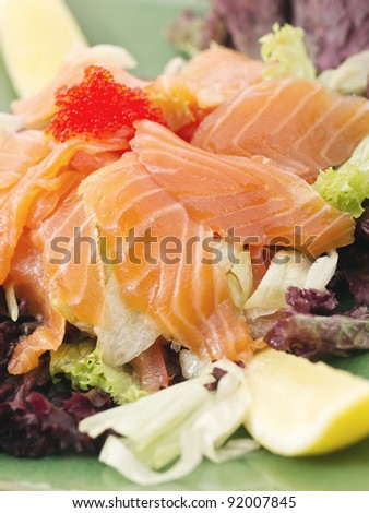 Extreme close-up of smoked salmon served with lemon and salad