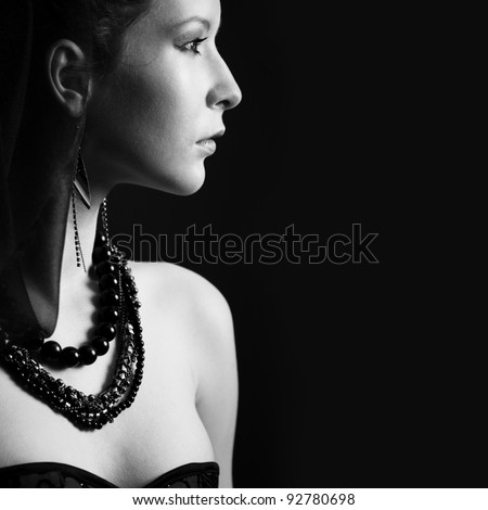Portrait beautiful young woman in profile on the black background, black and white