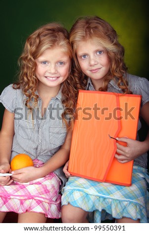 Portrait of two red hair sisters holding orange stuff