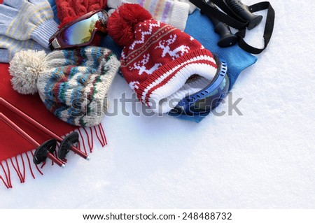 Ski background : winter snow sports skiing background with ski poles, goggles, bobble hats and gloves.  Space for copy.