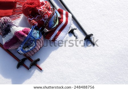 Winter snow sports skiing background with ski poles, goggles, bobble hats and gloves.  Space for copy.