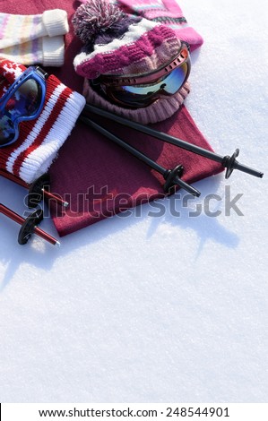 Winter sports skiing background with ski poles, goggles, bobble hats and gloves.  Space for copy.