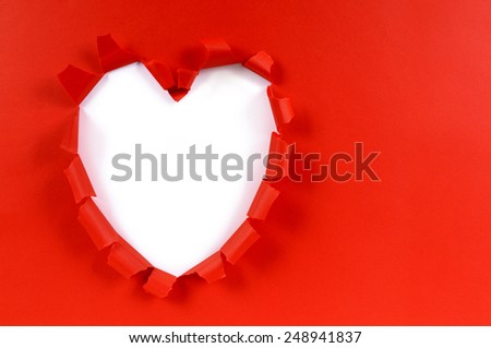 Valentine card background of heart shape torn in red paper with white background space for copy.