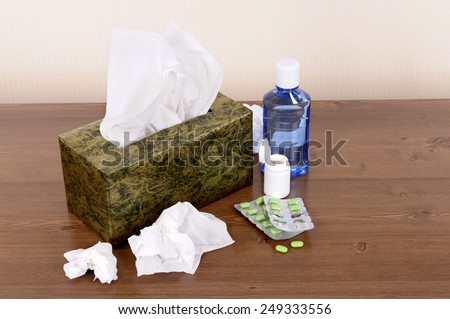 Tissue box, used tissues, various medicine.  Copy space.
