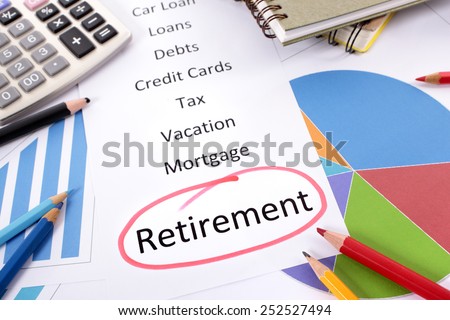 Retirement plan : The word Retirement circled in red with a list of saving and debt obligations surrounded by graphs, charts, books and pencils.  Retirement saving planning concept.