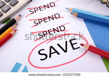 Saving plan : The word Save circled in red below a list of spending surrounded by pencils, graphs, books and calculator.  Spending, saving and planning concept.