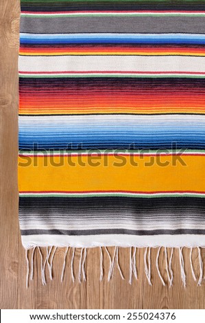 Mexican background with traditional serape blanket or rug on a wood floor.  Space for copy.