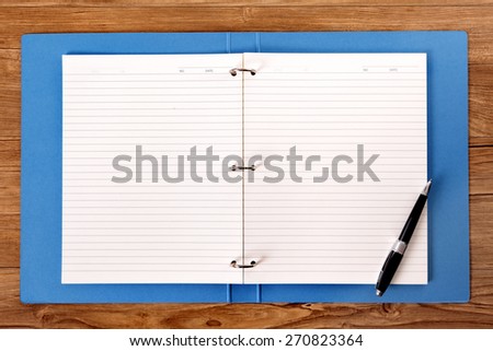 Writing book on student desk, ballpoint pen, copy space