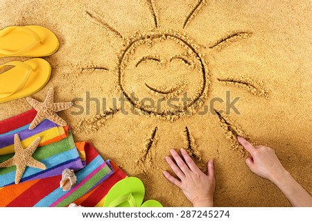Summer beach vacation, child drawing smiling face sun