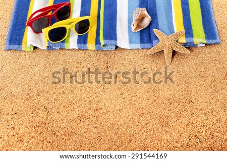 Summer border beach background, sunglasses, towel, copy space.