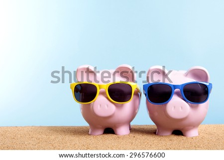 Vacation or retirement saving money concept, piggy banks on beach.  Copy space.