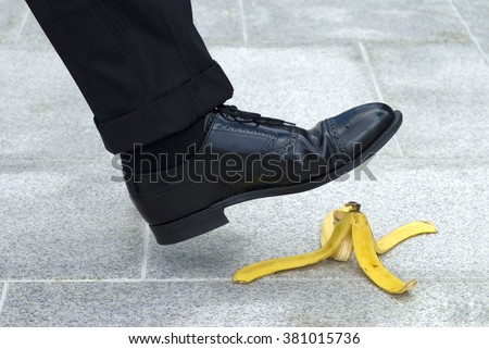Business man stepping on banana skin peel, work accident concept