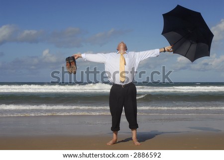 Senior business man sunbathing with arms outstretched on an empty tropical beach.  Retirement freedom, vacation or escaping concept.  Copy space.