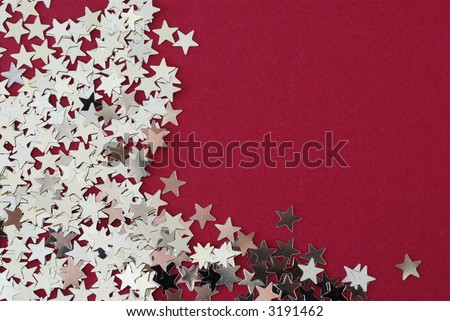 Silver stars scattered on red cloth board.  Note that the background has a cloth texture.