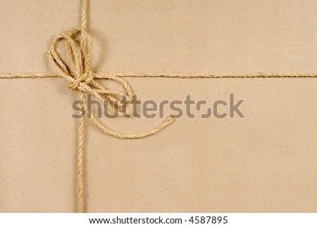 Brown cardboard box or parcel with string tied in a bow (with plenty of space for copy).