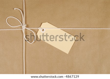 Parcel wrapped in mottled brown paper with cream cotton string and buff address label.