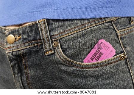Concert ticket : Two pink or purple admit one movie or theater tickets in the front pocket of an old faded pair of denim jeans.