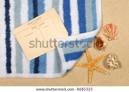 Seashore background with postcards shells beach towel and starfish (please note that the postcards are vintage and therefore faded and slightly stained).