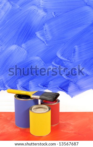 Partly painted blue wall with red floor, paint and paintbrushes (blue and red brushstrokes are intentionally messy).