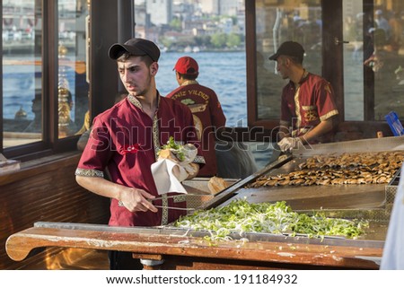 ISTANBUL - MAY 02: Turkish man sells deep fried fish to tourists at Eminonu on May 02, 2014 in Istanbul. Eating on the street is a part of local life in here. entertainment and travel of Istanbul.