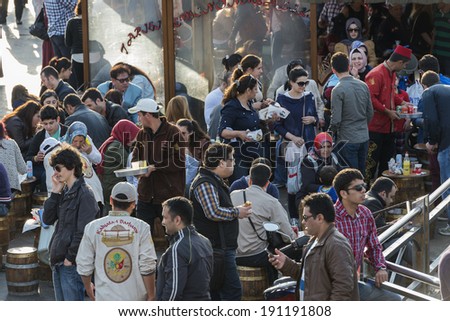 ISTANBUL, TURKEY - MAY 02, 2014:crowd in Eminou District. Eminonu Square, people eating fish. Eminonu Square is so crowded on day.People watching golden horn.