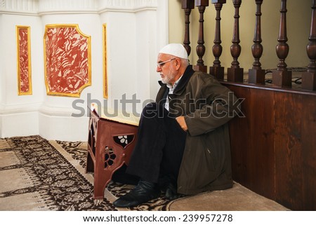 ISTANBUL, TURKEY - DECEMBER 25, 2014:Turkish man reading the Koran at the Ortakoy mosque in istanbul.