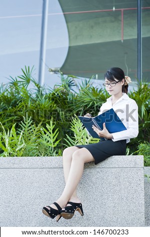 Beautiful Asian business woman sitting and take note in front of officer.