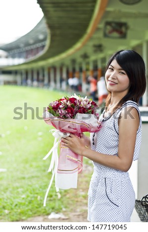 Beautiful Asian woman in love holding flower bouquet.