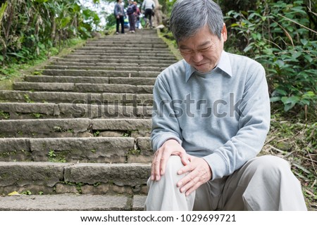 old man with knee problem in the moutain