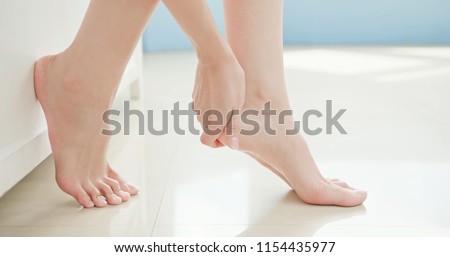 beauty woman apply cream with foot at home