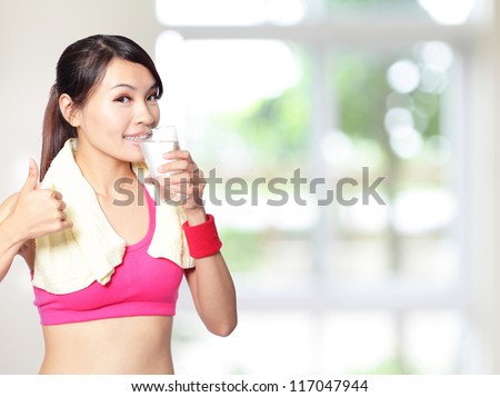 sport girl drinking water and show thumb up after sport with nature green background, model is a asian woman