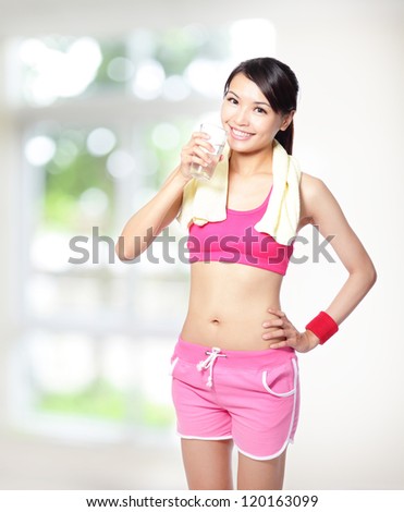 sport girl drinking water after sport and smile to you with nature green background, model is a asian woman