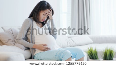 pregnant woman sit on the sofa and feel depression at home